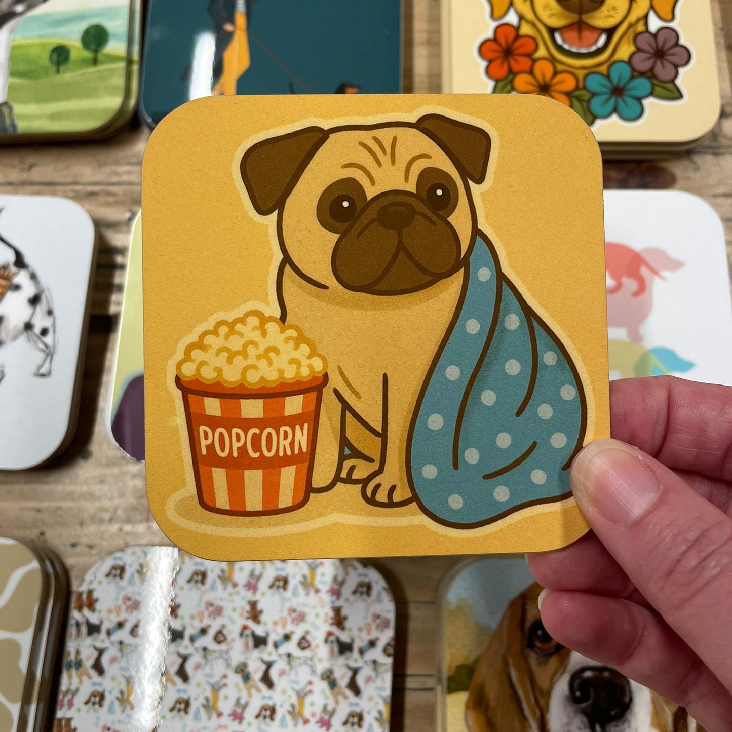 Collection of colorful coasters with cartoon dog designs on a wooden surface.